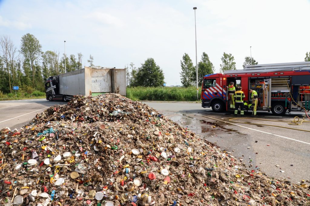 Vrachtwagen lost volledige lading afval op parkeerplaats